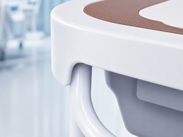 Close up of a seamless molded seat and welded frame joints on a mobile commode chair
